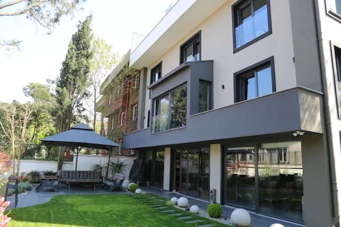 Bambu Yapım binasının ağaçlar ve bahçeyle çevrili dış cephesi
